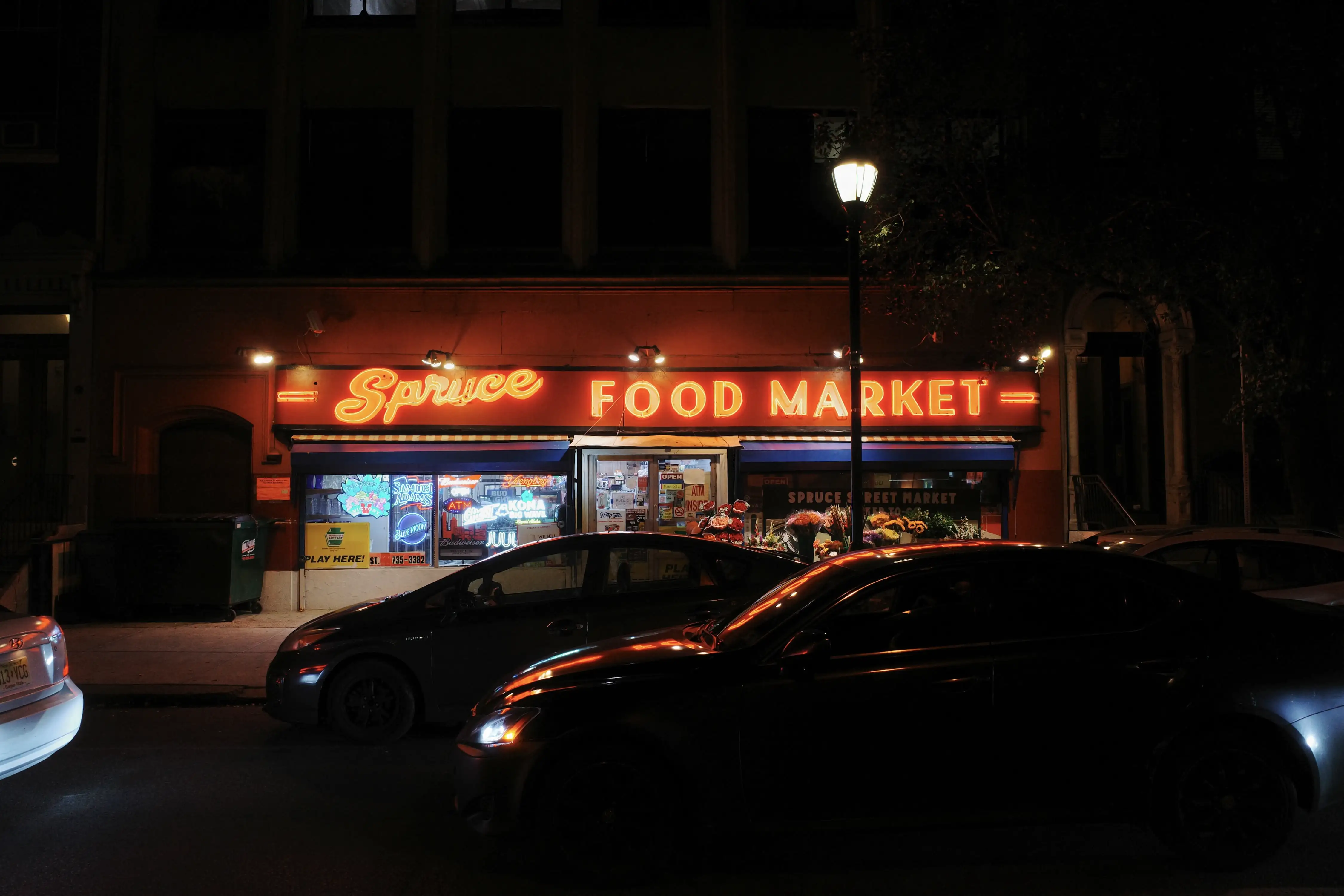 Spruce Street Market's neon sign glowing at night