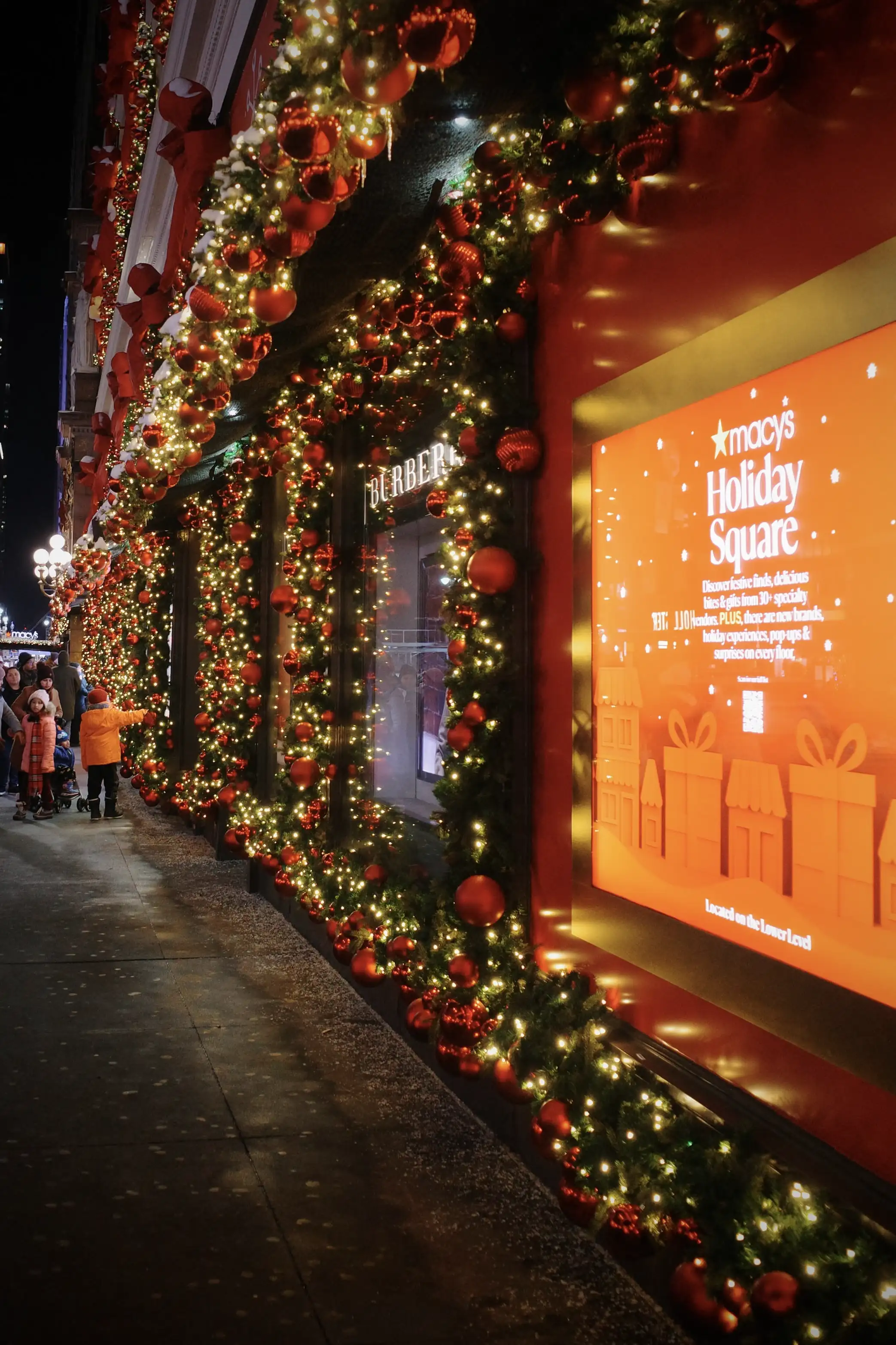 Holiday garland and lights along a Manhattan storefront